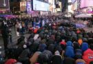 Umat Muslim New York Tarawih Perdana Di Times Square Amerika Serikat dengan latar belakang iklan LED yang menyala terang